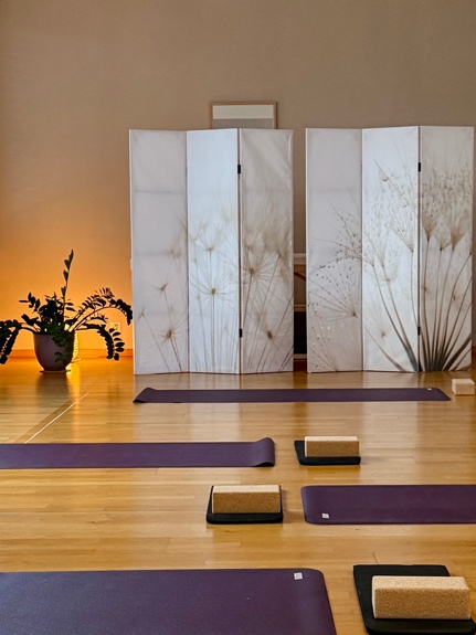 Yogaraum der Praxis am Abend mit Matten und Paravents
